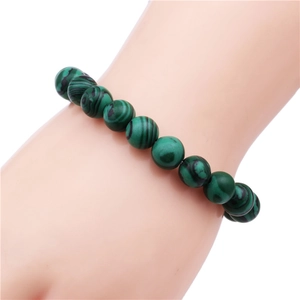 Macro detail of 10mm malachite beaded bracelet with natural green stone textures