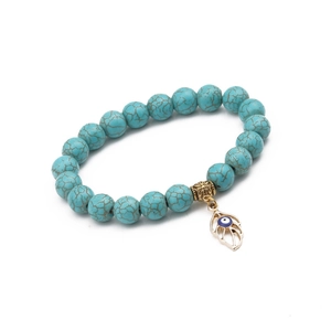 Detail of 10mm turquoise beads bracelet with golden evil eye leaf pendant on white background