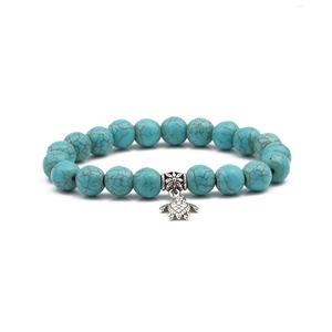 Detail of 10mm turquoise beaded bracelet with silver turtle pendant and ethnic spacers
