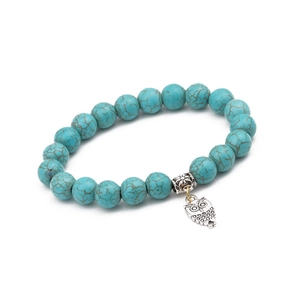 Detailed macro view of sky blue turquoise beads with vintage silver owl charm bracelet