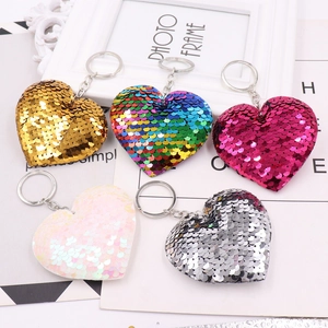 Detailed view of five colorful heart-shaped sequin keychains with metallic rings