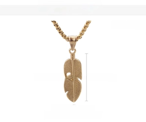 Detail view of 18K gold plated feather pendant with size specs 40mm height and 13mm width