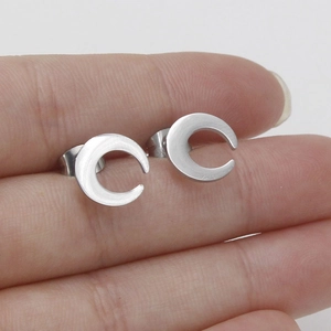 Brushed stainless steel crescent moon stud earrings shown held by fingers for scale
