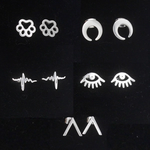 Detail view of five stainless steel stud earrings featuring moon, paw, and heart designs