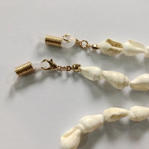 Detail of natural conch shell eyeglass chain with gold lobster clasp and rubber loops