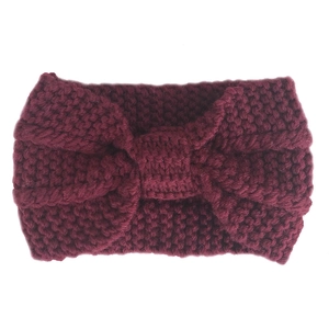 Detail of burgundy thick knit ear-warmer headband with bohemian style bow texture