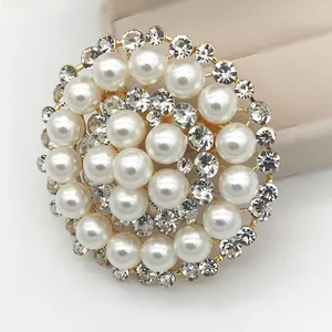 Macro shot of gold circular brooch featuring tiered white pearls and sparkling rhinestones