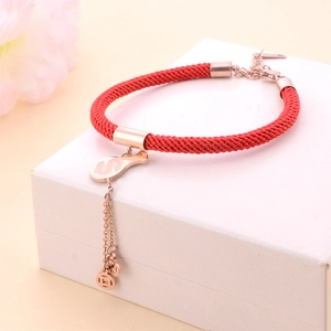 Rose gold money bag and coin charms on a red woven lucky string bracelet for fortune