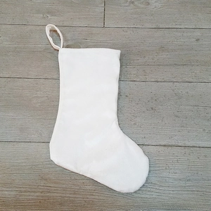 Close-up of a white plush Christmas stocking for DIY sublimation on grey wood