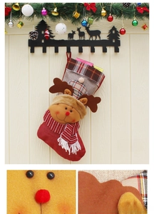 Détail d'une chaussette de Noël rouge avec renne en 3D et bordure festive en tissu à carreaux
