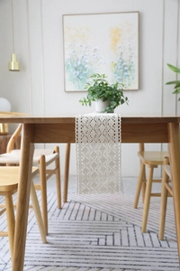 Detailed view of beige handmade crochet table runner with intricate lace patterns