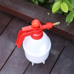 White manual pressure spray bottle with red pump and brass nozzle for garden watering