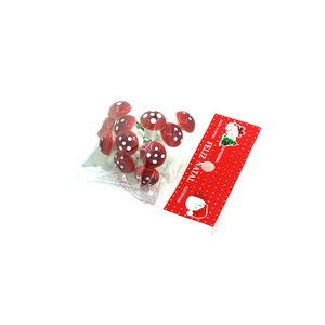 Close-up of mini red mushroom ornaments with white spots for Christmas tree decoration