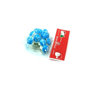 Close-up of blue faux mushroom clusters with white dots in Boas Festas holiday packaging