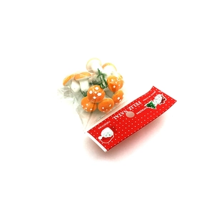 Macro detail of red miniature Christmas foam mushrooms in festive holiday packaging