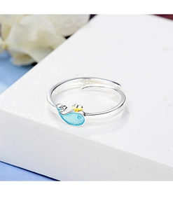 Detail of silver whale ring with blue finish and gold crown on a display stand