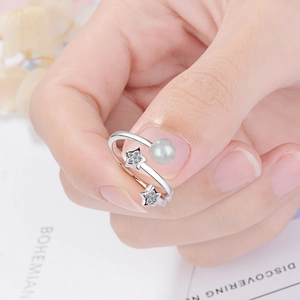 Adjustable silver star ring with moonstone bead and zircon stones on model's finger