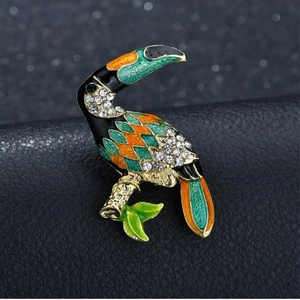 Macro shot of toucan brooch featuring detailed enamel and sparkling rhinestones