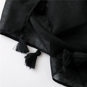 Macro detail of black leopard scarf fabric with sheer texture and fringe edges