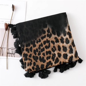 Close-up of leopard print scarf with black tassels, cotton linen texture details