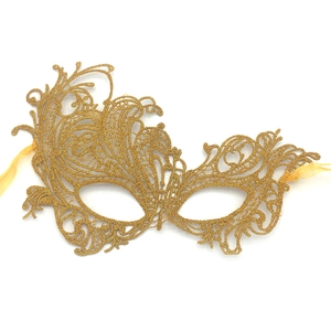 Detailed macro view of the intricate golden lace texture and Phoenix pattern on the mask