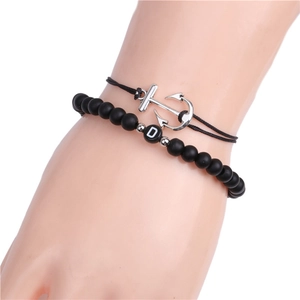 Detail view of 6mm matte black stone bead bracelet with letter D and silver anchor charm
