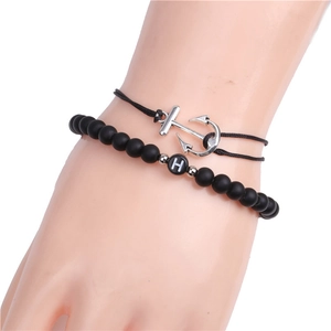 Detail of 6mm matte black beads bracelet with letter H and silver anchor charm on wrist