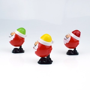 Three plastic wind-up Santa Claus toys hopping with open mouths in various colors