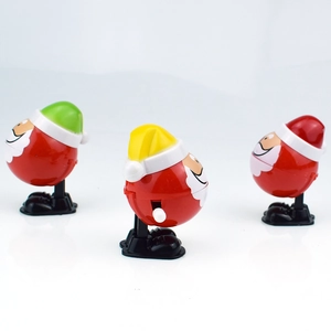 Detailed view of three wind-up Santa Claus toys in red, yellow, and green festive hats