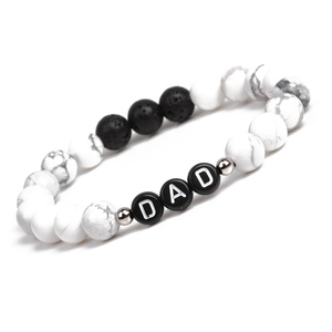 Détail d'un bracelet en perles de marbre blanc avec perles de lettres DAD sur fond blanc