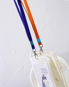 Close-up of woven lanyards with lobster clasps attached to card holder and phone case