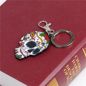 Detail of colorful sugar skull keychain with enamel finish on a vintage book