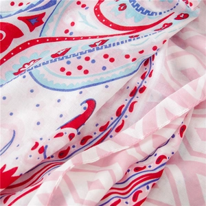 Détail du tissu léger à imprimé paisley avec des franges délicates et des pompons