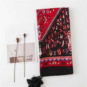 Détail d'une écharpe bohème à imprimé floral avec glands noirs et motifs ethniques