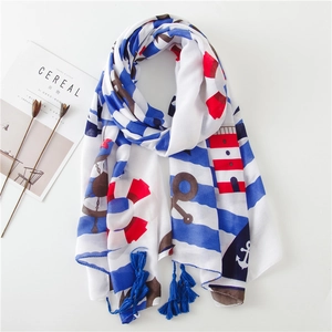 Détail d'un châle en coton et lin aux motifs nautiques avec pompons bleus