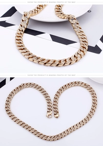 Close-up of gold iced out Cuban link chain with detailed crystal pave and heart arrangement