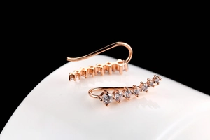 Detail of rose gold ear crawler with gradient white zircons on ceramic stand