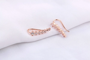 Detail of rose gold crawler earrings featuring seven graduated round clear cubic zirconia