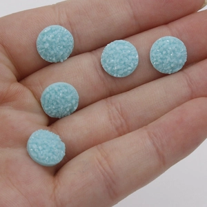 Macro detail of 10mm light blue druzy resin cabochons with sparkling mineral texture