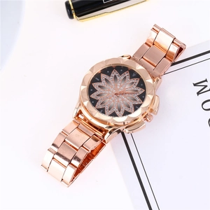 Montre femme en or rose avec motif lotus en strass étincelants et lunette facettée