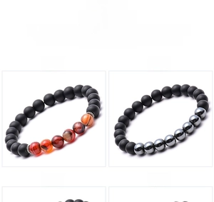 Dettaglio di bracciali in pietra naturale da 8mm con texture in lava e perle di legno