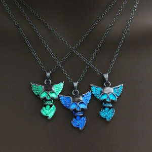 Luminous dragon skull pendant necklaces glowing in green, blue and cyan colors in dark