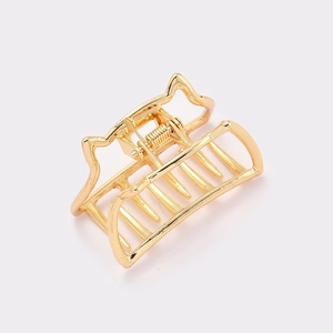 Close-up of golden metal cat ear hair claw clip with spring mechanism and polished finish