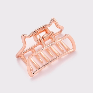 Rose gold metal hair claw clip with minimalist cat ear design on light grey background