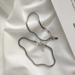 Detail of vintage S925 silver woven rope chain bracelet with lobster clasp on white silk