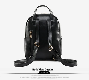 Rear view of black faux leather backpack featuring golden zippers and a vertical back pocket