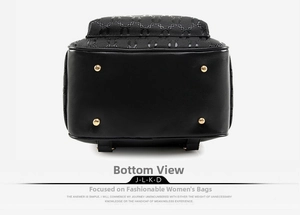 Detail view of the black backpack base featuring four gold metal protective feet