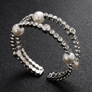 Detailed close-up of double-layer open bangle with white pearls and sparkling rhinestones
