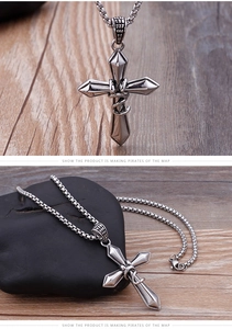 Macro detail of silver cross necklace with serpent motif on rustic wooden background
