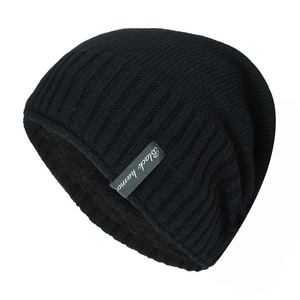 Dettaglio del berretto in maglia nera con calda fodera in pile ed etichetta Black humor